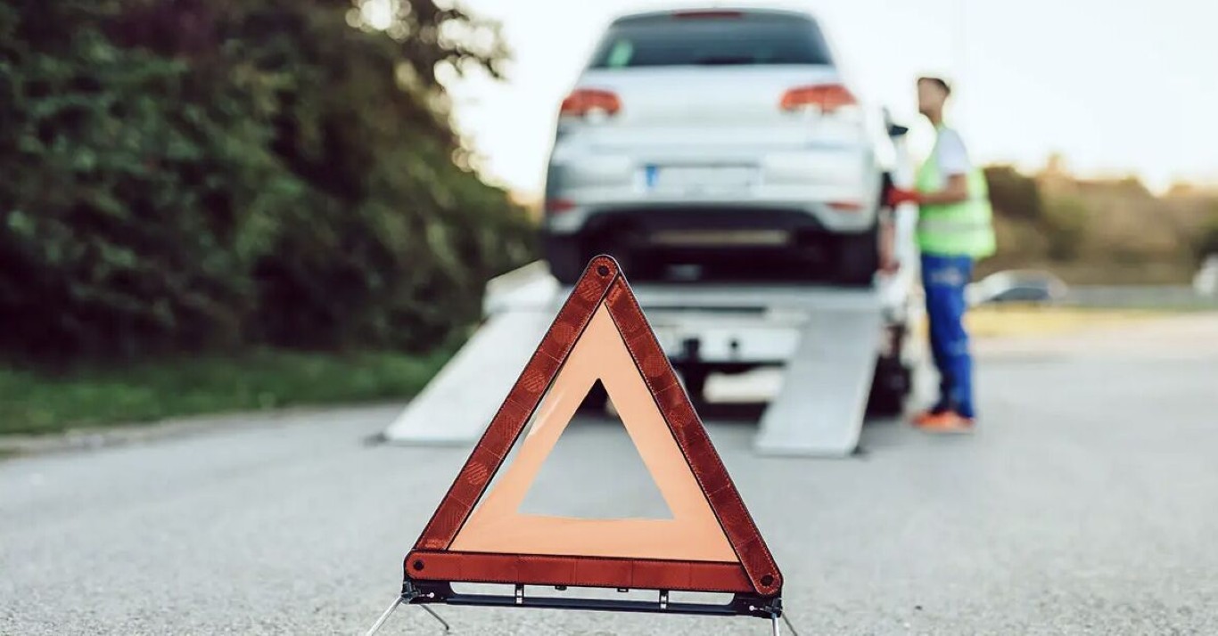 Tow truck loading an SUV onto a flatbed for a long distance tow