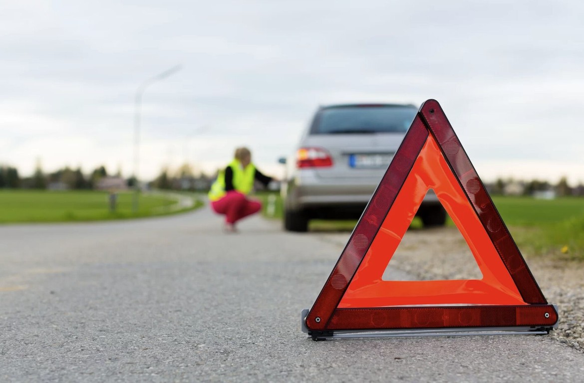 Roadside assistance technician helping a stranded driver on a rural road